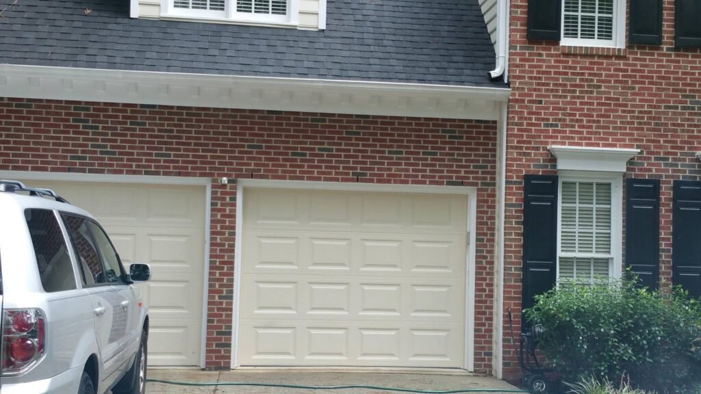 Double residential garage doors on brick house